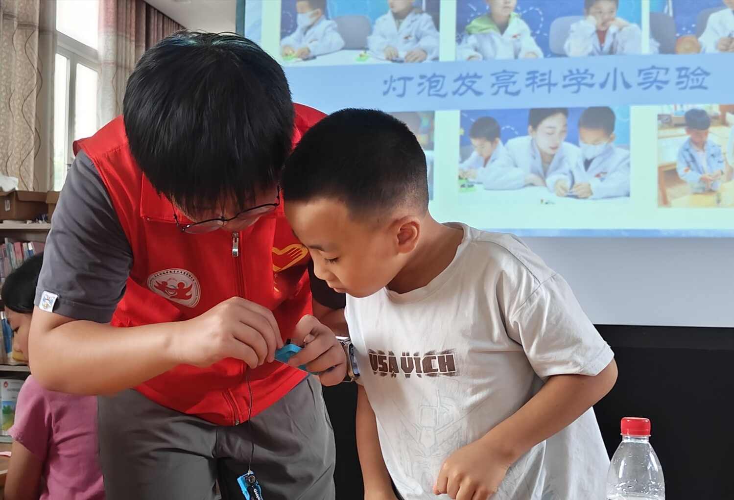 图8：图为团队成员与小朋友完成灯泡实验.jpg
