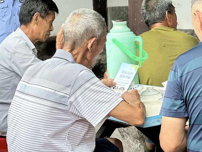 图8：图为老人们阅读宣传单.jpg